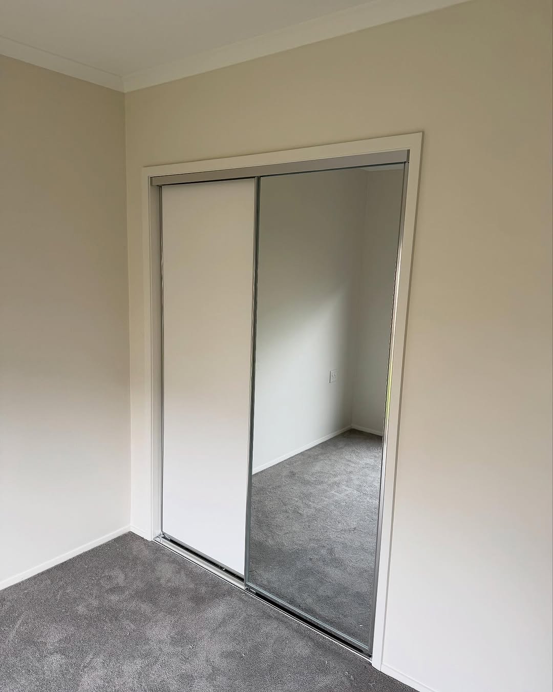 Bedroom with silver-framed sliding wardrobe doors